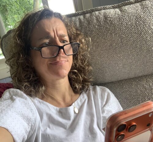 Andrea Gribble wearing glasses, trying to read her phone